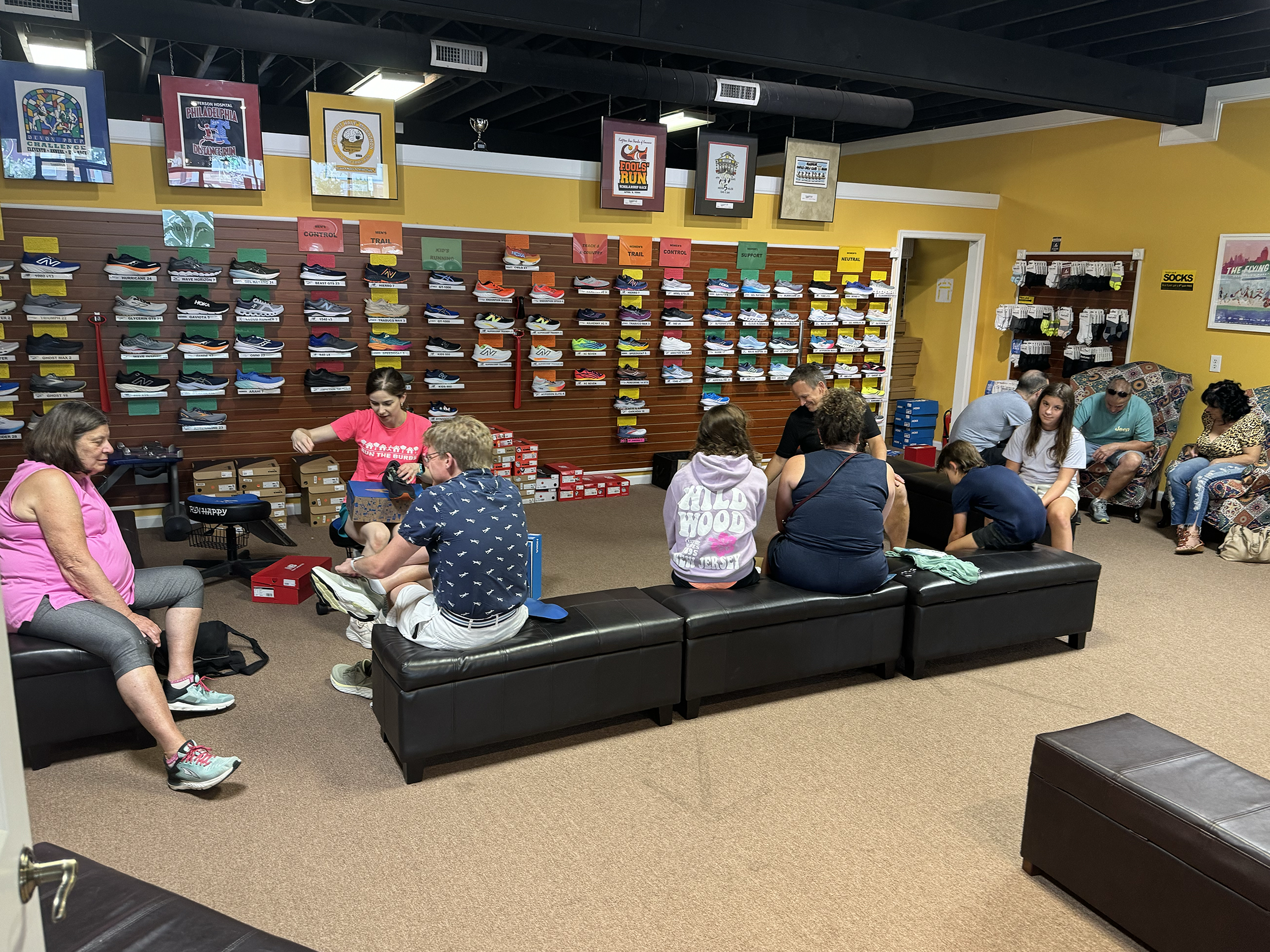 Customers getting fitted for sneakers in the back of The Running Place, a running and walking shoe store in Newtown Square, PA.